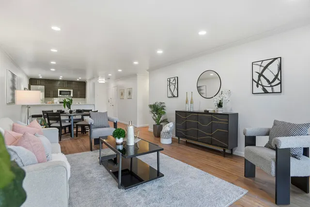 a living room with furniture a rug and kitchen view