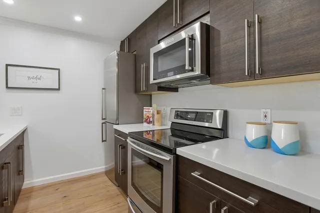 a kitchen with stainless steel appliances wooden cabinets and a stove top oven