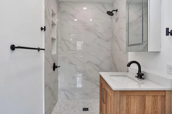 a bathroom with a sink vanity and shower