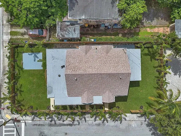 an aerial view of a house with a yard and a large tree