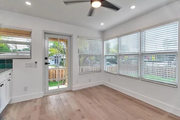 a view of an empty room with a window and wooden floor