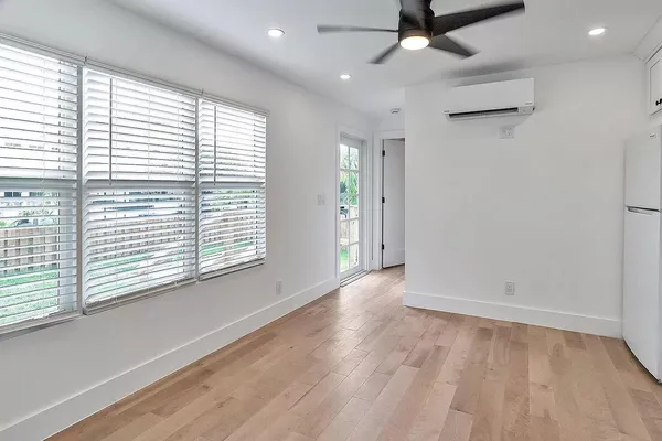 an empty room with a window and a ceiling fan