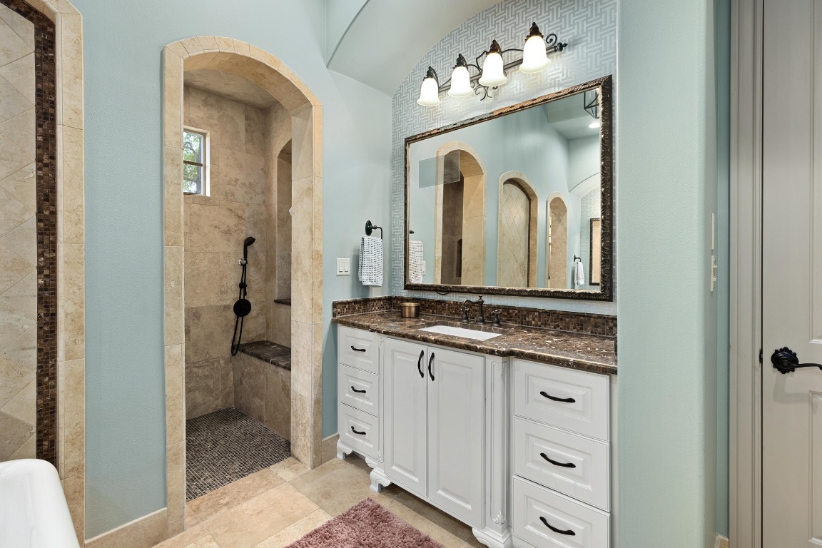 216 Vista Lane Georgetown, TX 78633 - Photo 24 of 40 a bathroom with a granite countertop sink a mirror and a shower