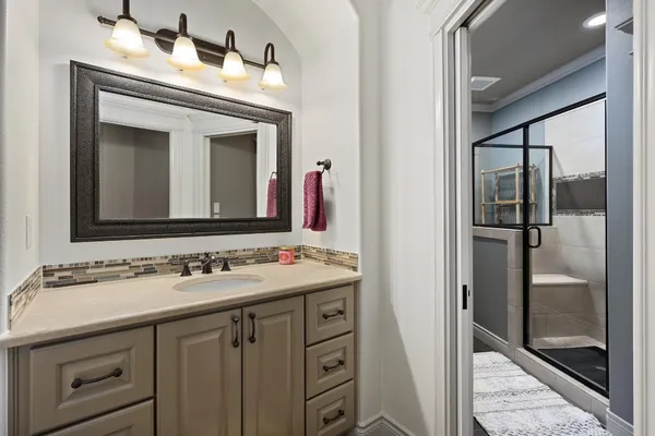 a bathroom with a granite countertop sink toilet a mirror and shower