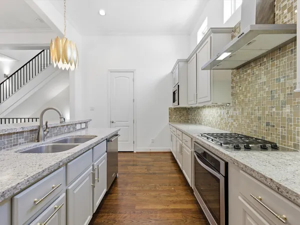 a kitchen with stainless steel appliances granite countertop a sink stove and cabinets