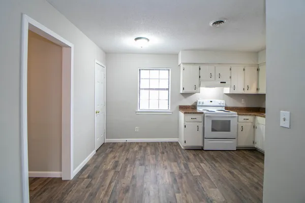 a kitchen with granite countertop white cabinets and white appliances