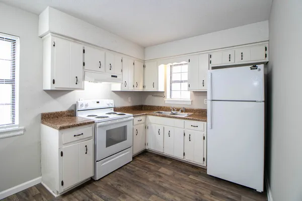 a kitchen with granite countertop white cabinets and white appliances