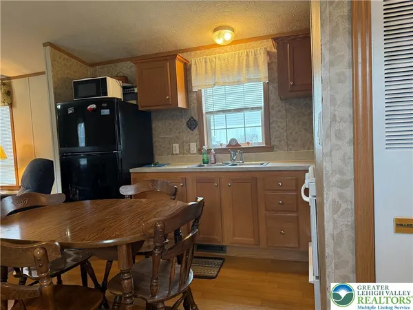 a kitchen with a table chairs and refrigerator