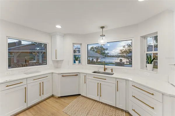 a large kitchen with stainless steel appliances granite countertop a large counter top a sink a stove and a wooden floors