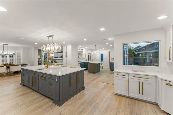 a kitchen with kitchen island granite countertop a sink stainless steel appliances and cabinets