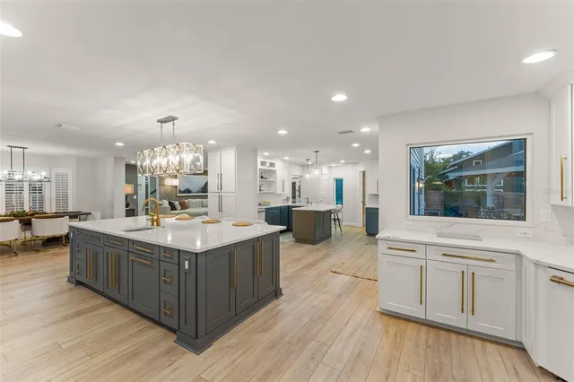 a kitchen with kitchen island granite countertop a sink stainless steel appliances and cabinets