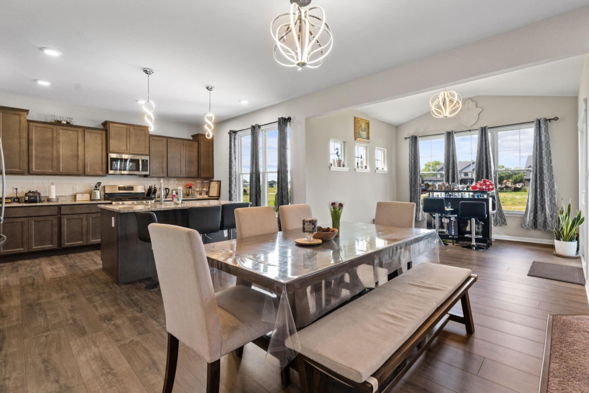 9872 Sumter Court Cedar Lake, IN 46303 - Photo 3 of 18 a living room with stainless steel appliances granite countertop furniture a fireplace a rug kitchen view and a chandelier