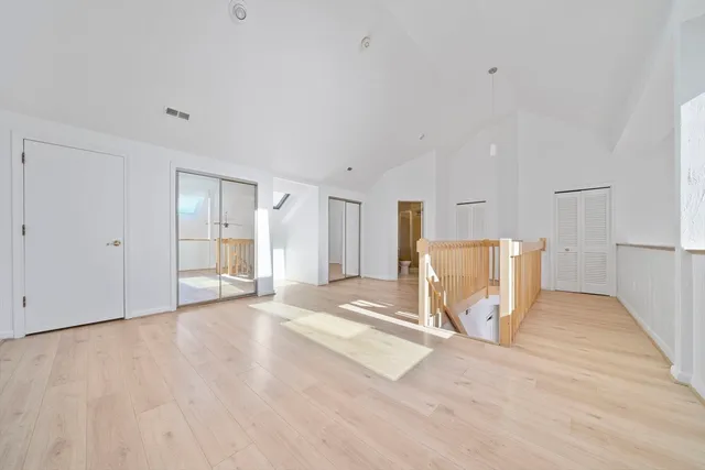 a view of a livingroom with wooden floor and a refrigerator