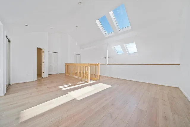 a view of an empty room with wooden floor