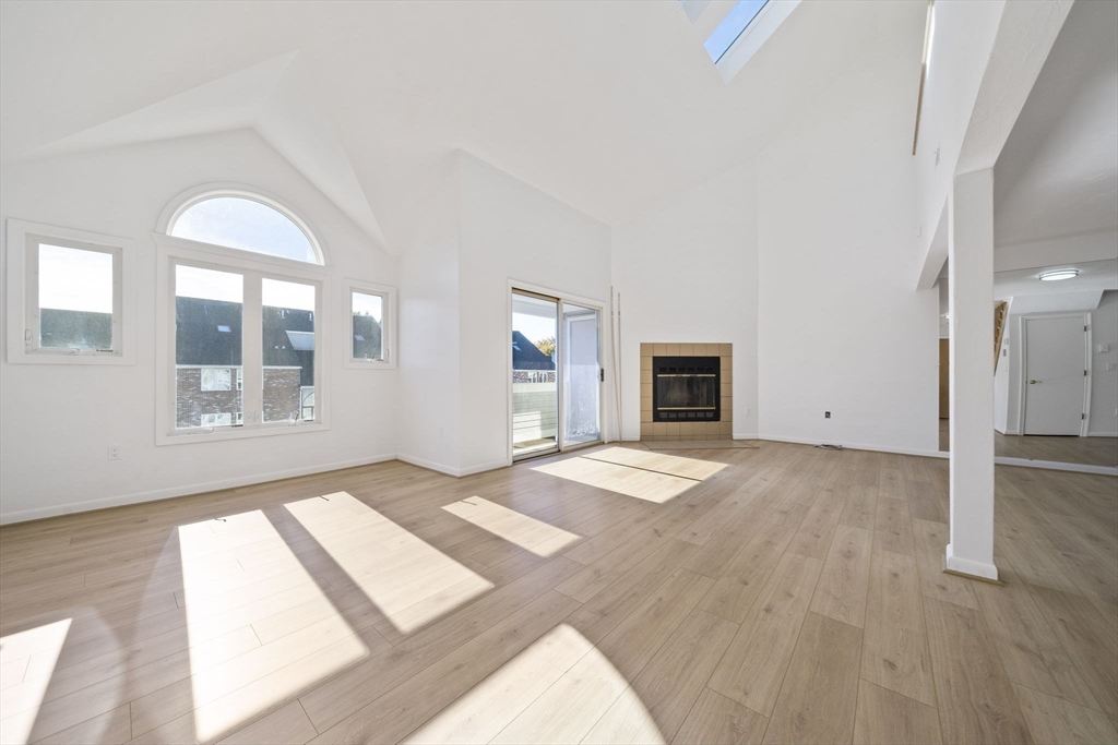 110 Burkhall Street, Unit H Weymouth, MA 02190 - Photo 2 of 18 a view of an empty room with wooden floor and a window