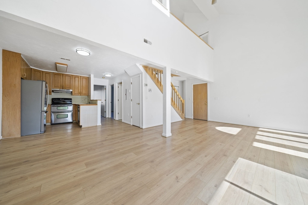 110 Burkhall Street, Unit H Weymouth, MA 02190 - Photo 3 of 18 a view of a kitchen with a sink and a refrigerator