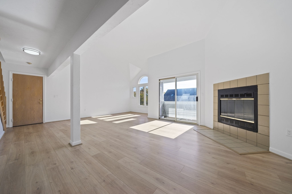 110 Burkhall Street, Unit H Weymouth, MA 02190 - Photo 4 of 18 a view of empty room with wooden floor and fireplace