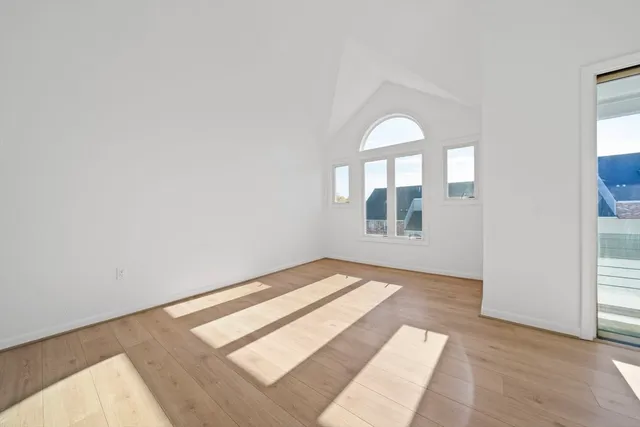 a view of a room that has wooden floor and window