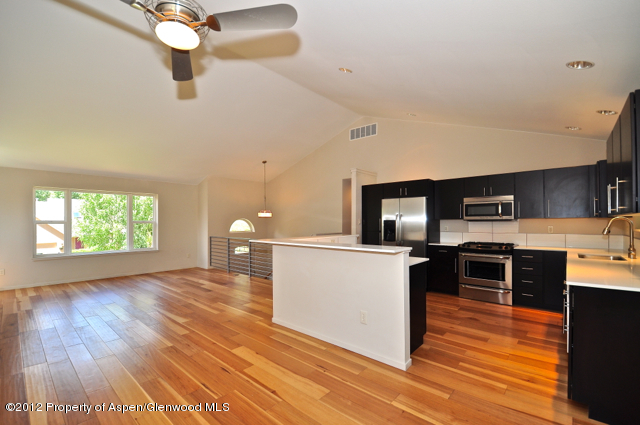 a kitchen with stainless steel appliances granite countertop a stove top oven a sink with wooden floors