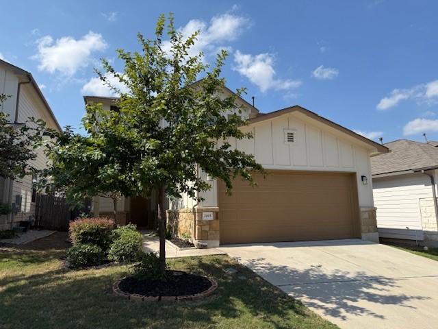 2015 Crimson Rosella Trail Austin, TX 78728 - Photo 2 of 20 View of front facade with board and batten siding, driveway, an attached garage, and stone siding