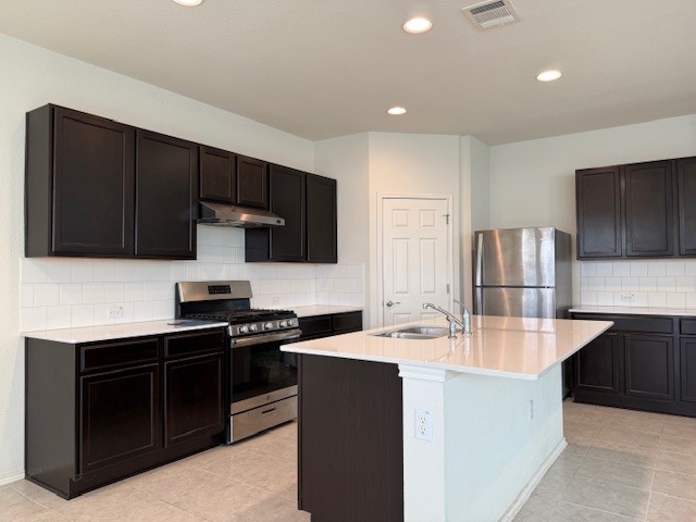 2015 Crimson Rosella Trail Austin, TX 78728 - Photo 5 of 20 Kitchen with tasteful backsplash, appliances with stainless steel finishes, recessed lighting, light tile patterned floors, and a kitchen island with sink