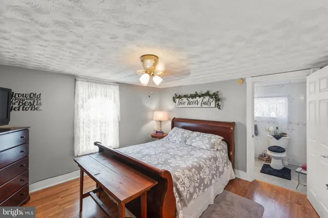 a bedroom with a large bed a flat tv screen and a dresser