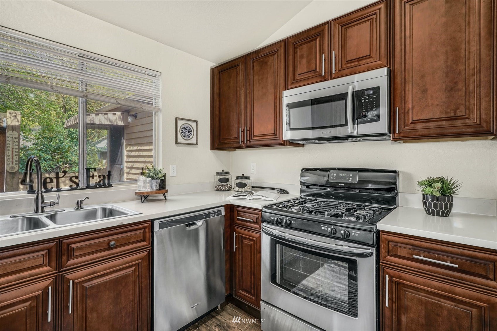 9103 183rd Avenue Northeast Redmond, WA 98052 - Photo 11 of 25 a kitchen with stainless steel appliances a stove microwave and sink