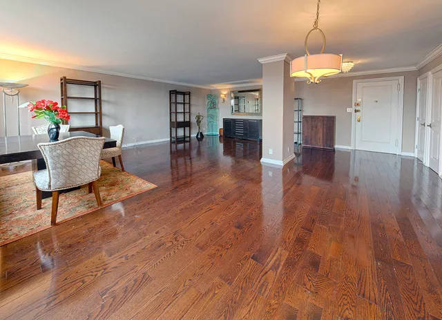 a dining room with wooden floor a glass table and chairs