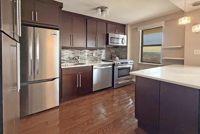 a kitchen with granite countertop stainless steel appliances and wooden cabinets