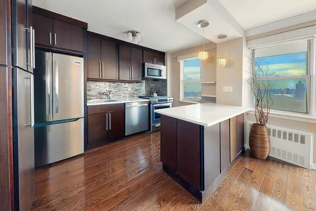 a kitchen with stainless steel appliances granite countertop a refrigerator a stove and a sink