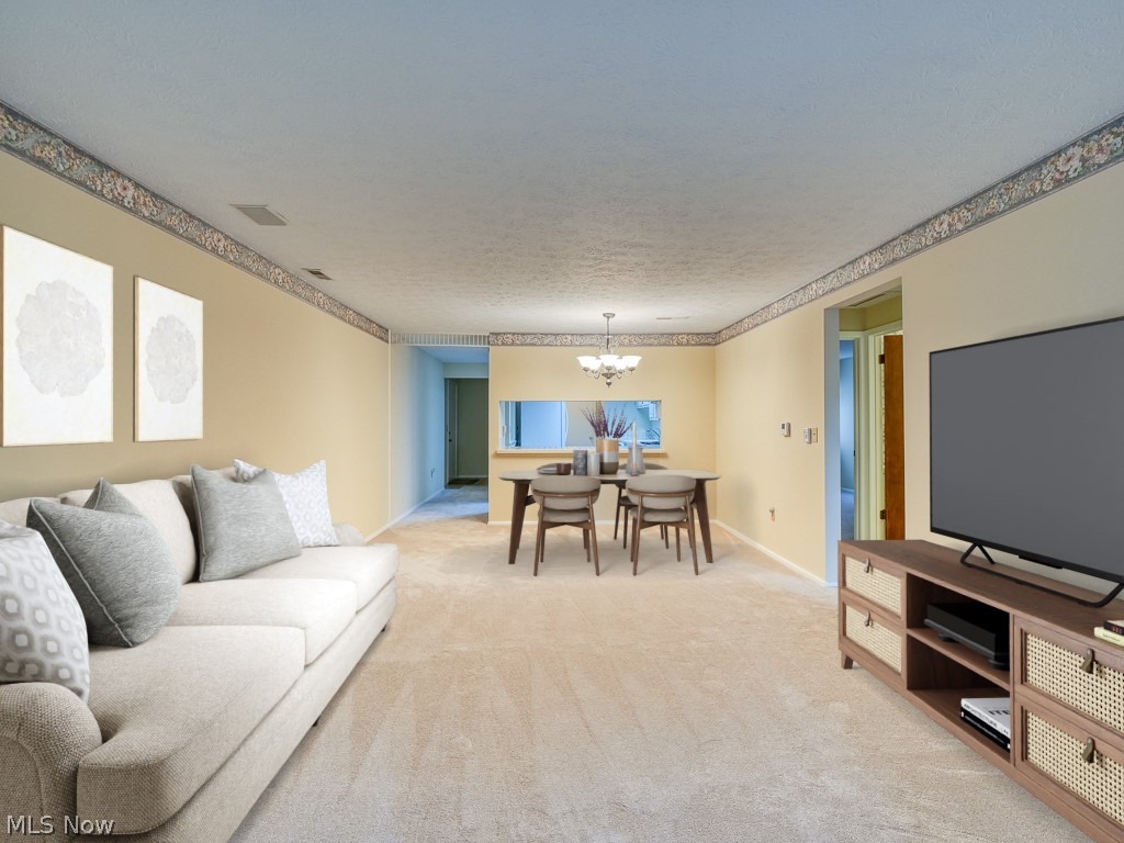 8941 West Ridge Road, Unit A Elyria, OH 44035 - Photo 14 of 30 Carpeted living room featuring an inviting chandelier and a textured ceiling-digitally staged