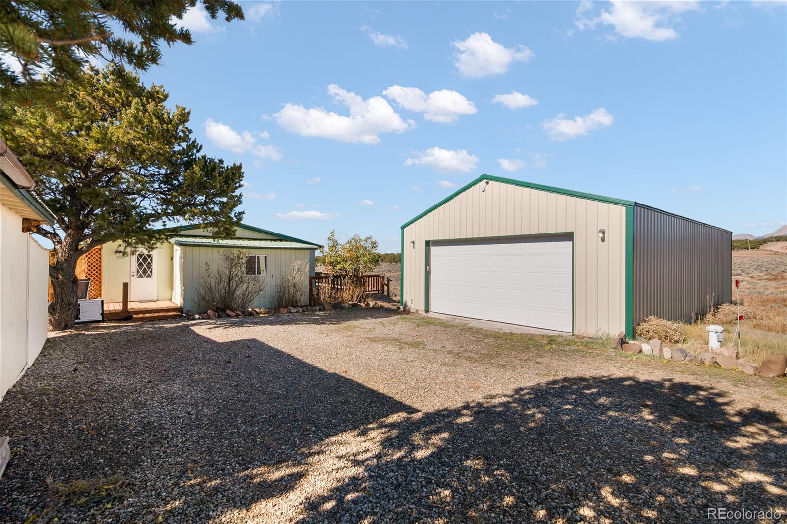 7027 Frelinghuysen Road Fort Garland, CO 81133 - Photo 11 of 47 a front view of a house with a yard and garage