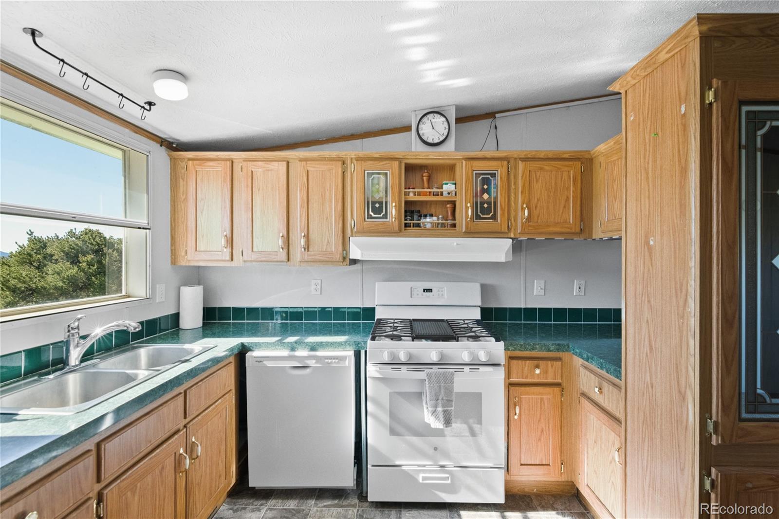 7027 Frelinghuysen Road Fort Garland, CO 81133 - Photo 17 of 47 a kitchen with a sink window and cabinets