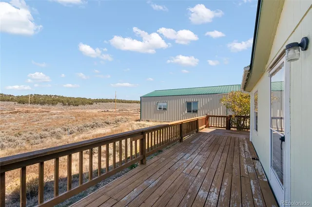 a view of roof deck with wooden floor and fence