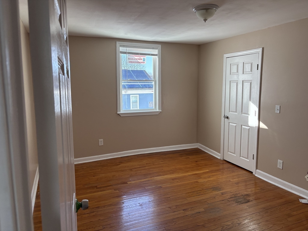 14 B School, Unit 2 Boston, MA 02124 - Photo 5 of 18 an empty room with wooden floor and windows