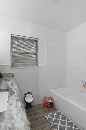 a bathroom with a granite countertop bathtub and sink