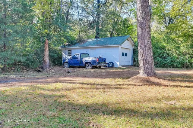 a view of a house with backyard and trees