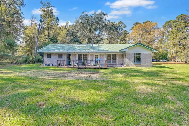 a view of a house with backyard and a tree