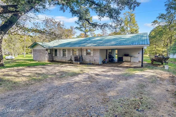 a view of a house with a yard and large tree