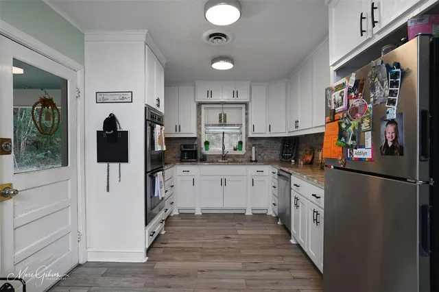 a kitchen with stainless steel appliances granite countertop a refrigerator and a stove top oven