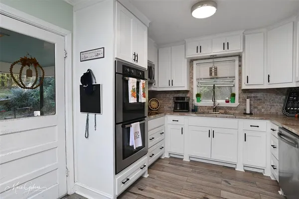 a kitchen with stainless steel appliances white cabinets and a refrigerator