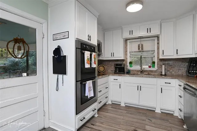 a kitchen with stainless steel appliances white cabinets and a refrigerator