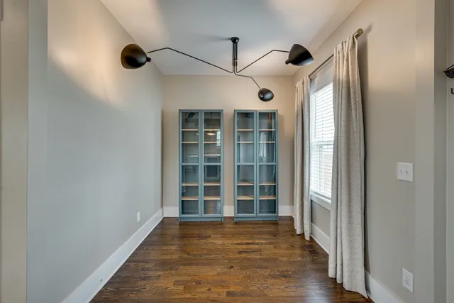 a view of empty room with wooden floor and windows