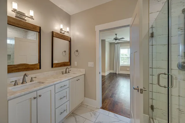 a bathroom with a double vanity sink a mirror and a shower