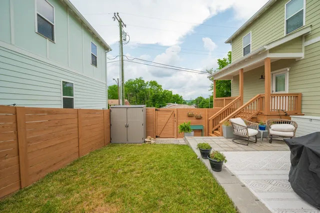 a view of a house with backyard and sitting area