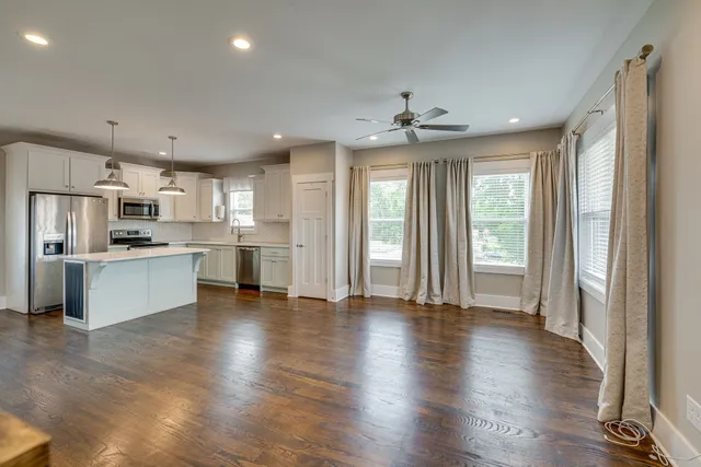a view of kitchen with refrigerator stove and wooden floor