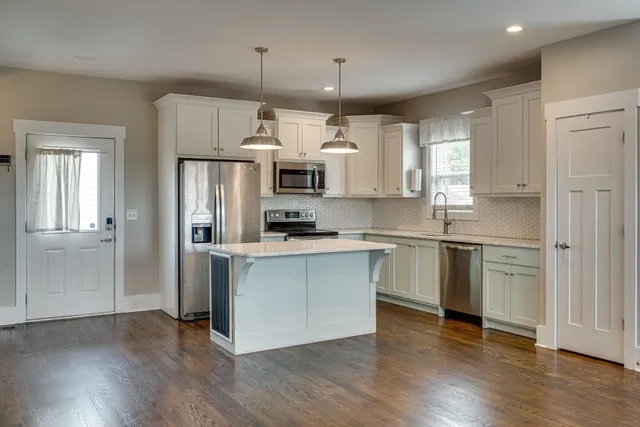 a kitchen with stainless steel appliances a refrigerator and a stove top oven