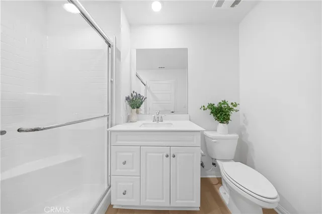a bathroom with a granite countertop toilet sink and mirror