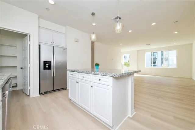 a large kitchen with stainless steel appliances granite countertop a refrigerator and a sink