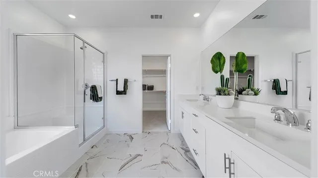a spacious bathroom with a double vanity sink a large mirror and shower